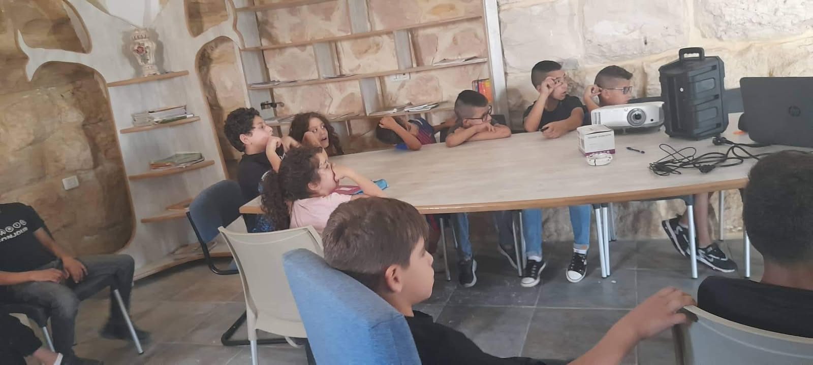 لقاء من حملة تشجيع القراءة حول الطاولة في غرفة المركز الحجرية.