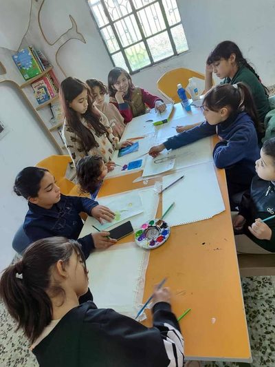 طلاب يرسمون بالألوان المائية، ضمن مسار سماء محررة.